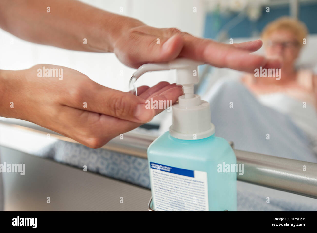 Krankenschwester mit Hand-Desinfektionsmittel auf Krankenhausbett Stockfoto