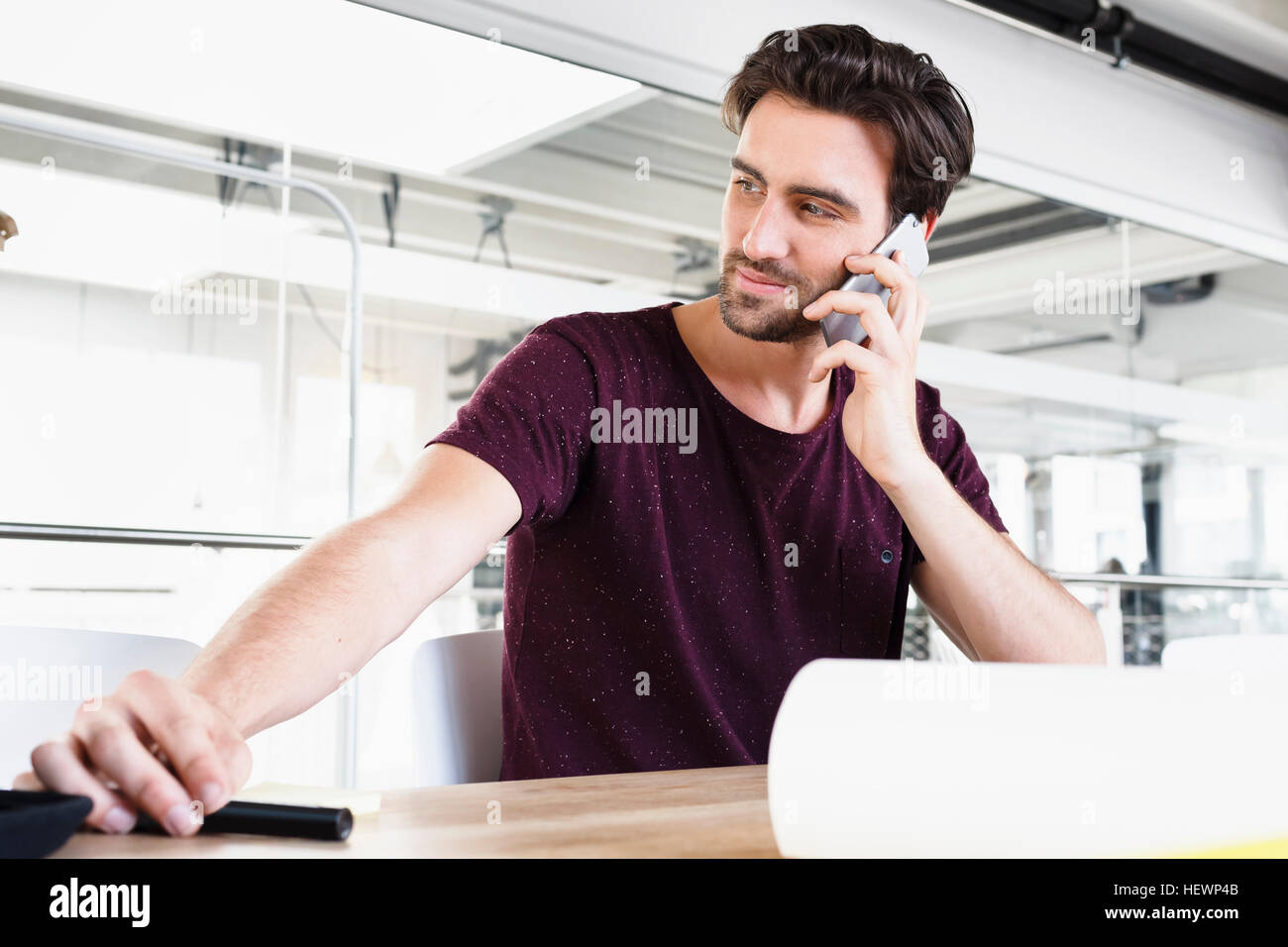 Mann im Büro mit Handy, wegschauen Stockfoto