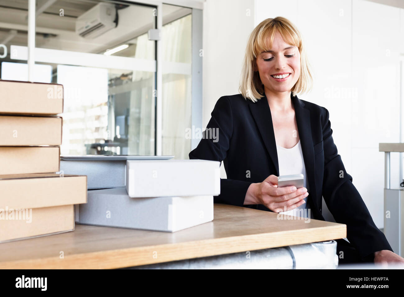 Business-Frau im Büro Smartphone lächelnd zu betrachten Stockfoto