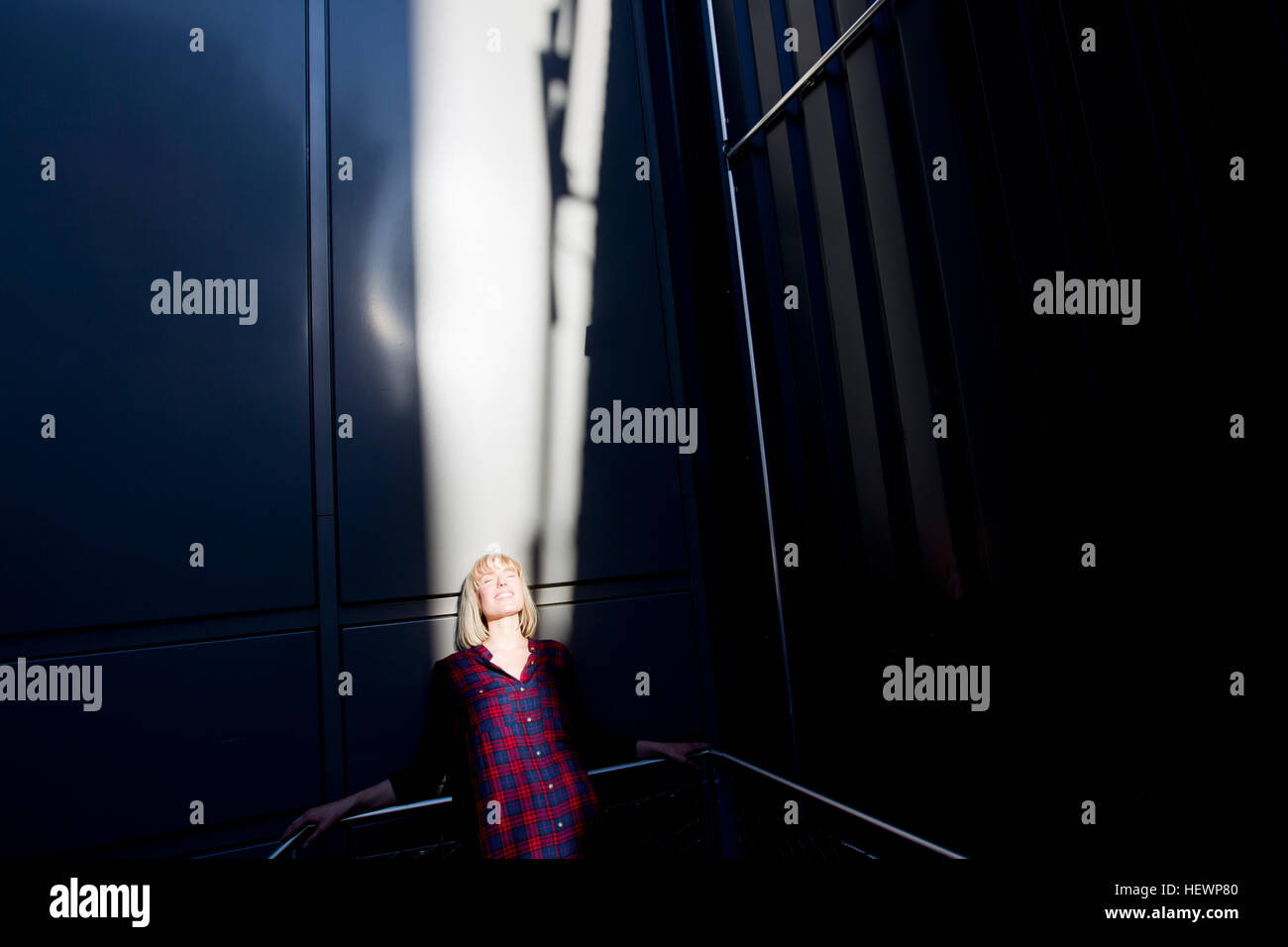Frau Aalen in der Sonne auf Treppe Stockfoto