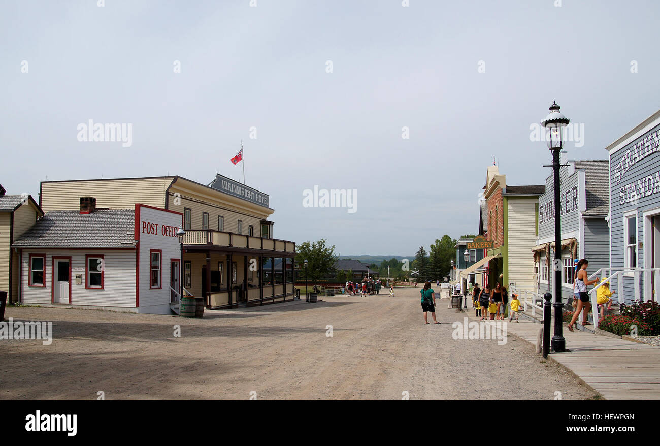 Dieses Foto zeigt frühe Transportszenen in Calgary, Kanada, mit Pferdekutschen, Oldtimer-Bussen und alten Autos aus dem historischen Dorf der Stadt im Heritage Park. Stockfoto