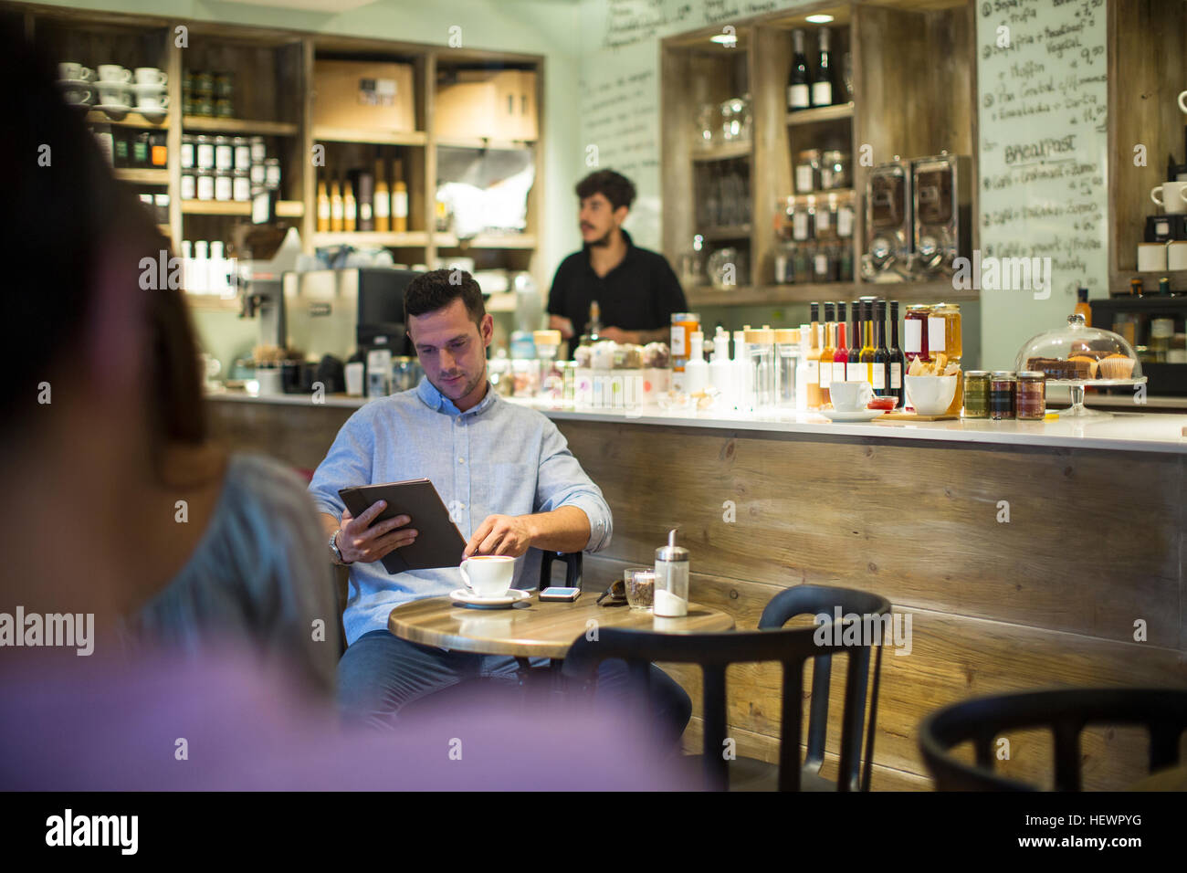 Mann sitzt im Café Surfen digital-Tablette Stockfoto
