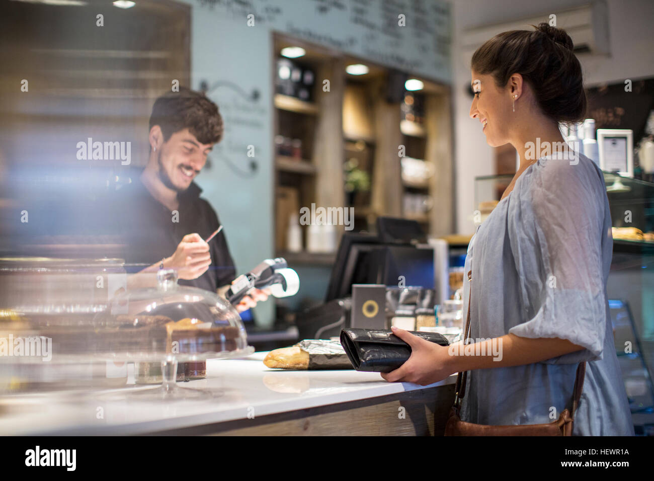Barista Berechnung Rechnung für Kundin am Café-Schalter Stockfoto