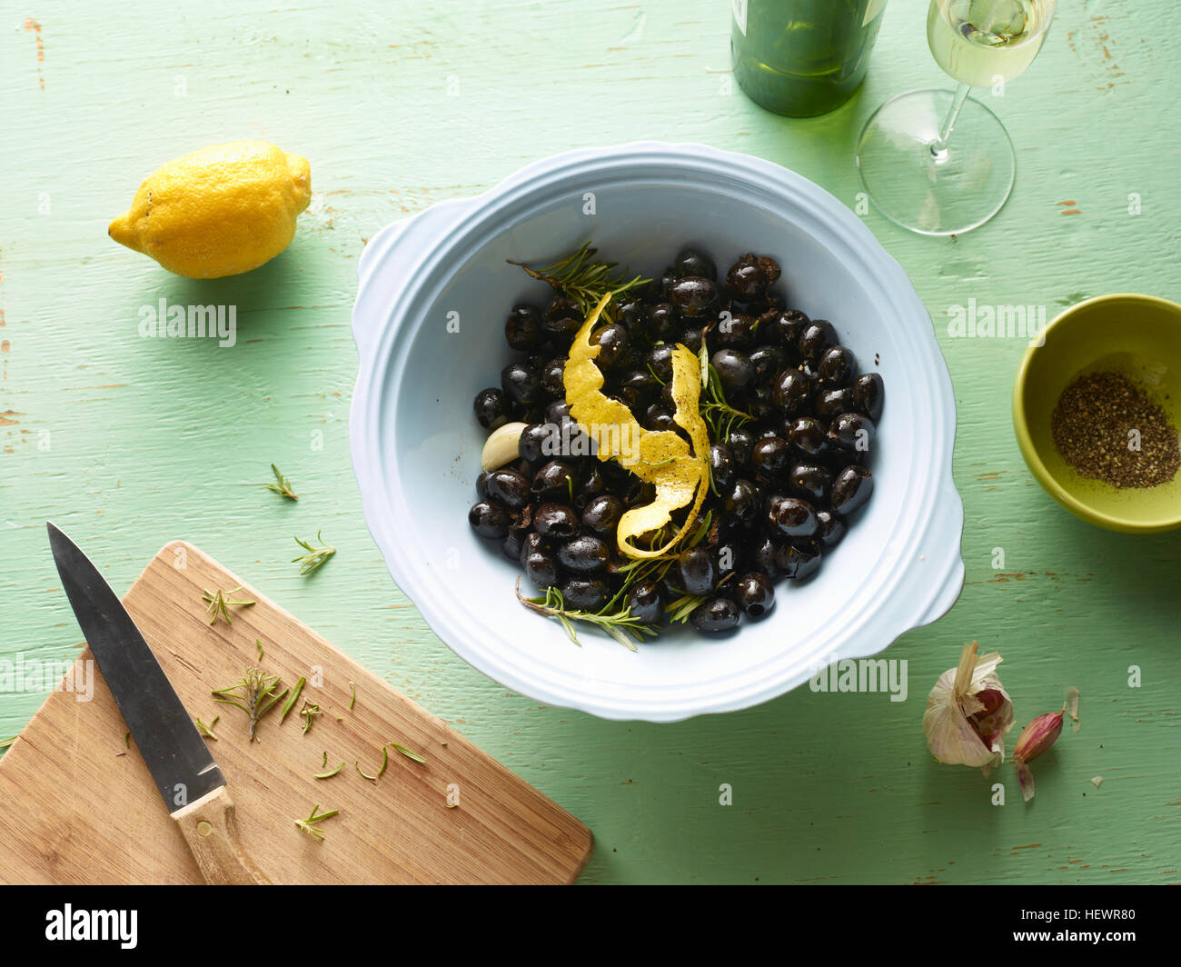 Draufsicht der Schale mit schwarzen Oliven mit Zitrone schälen auf Tisch Stockfoto