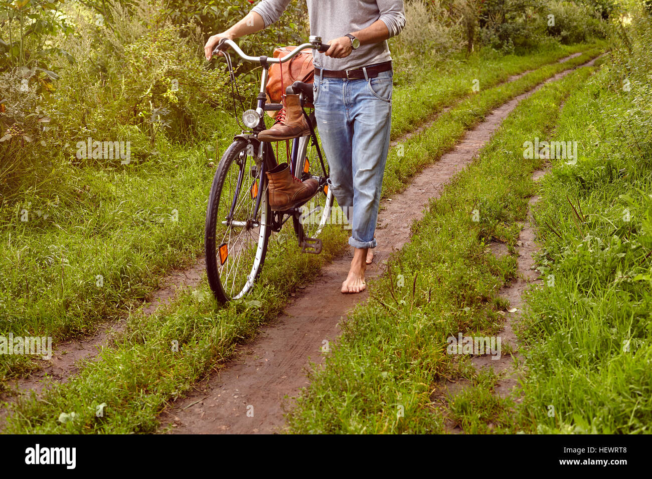 Hals abwärts Menschenbild drängen Fahrrad auf ländlichen Feldweg Stockfoto