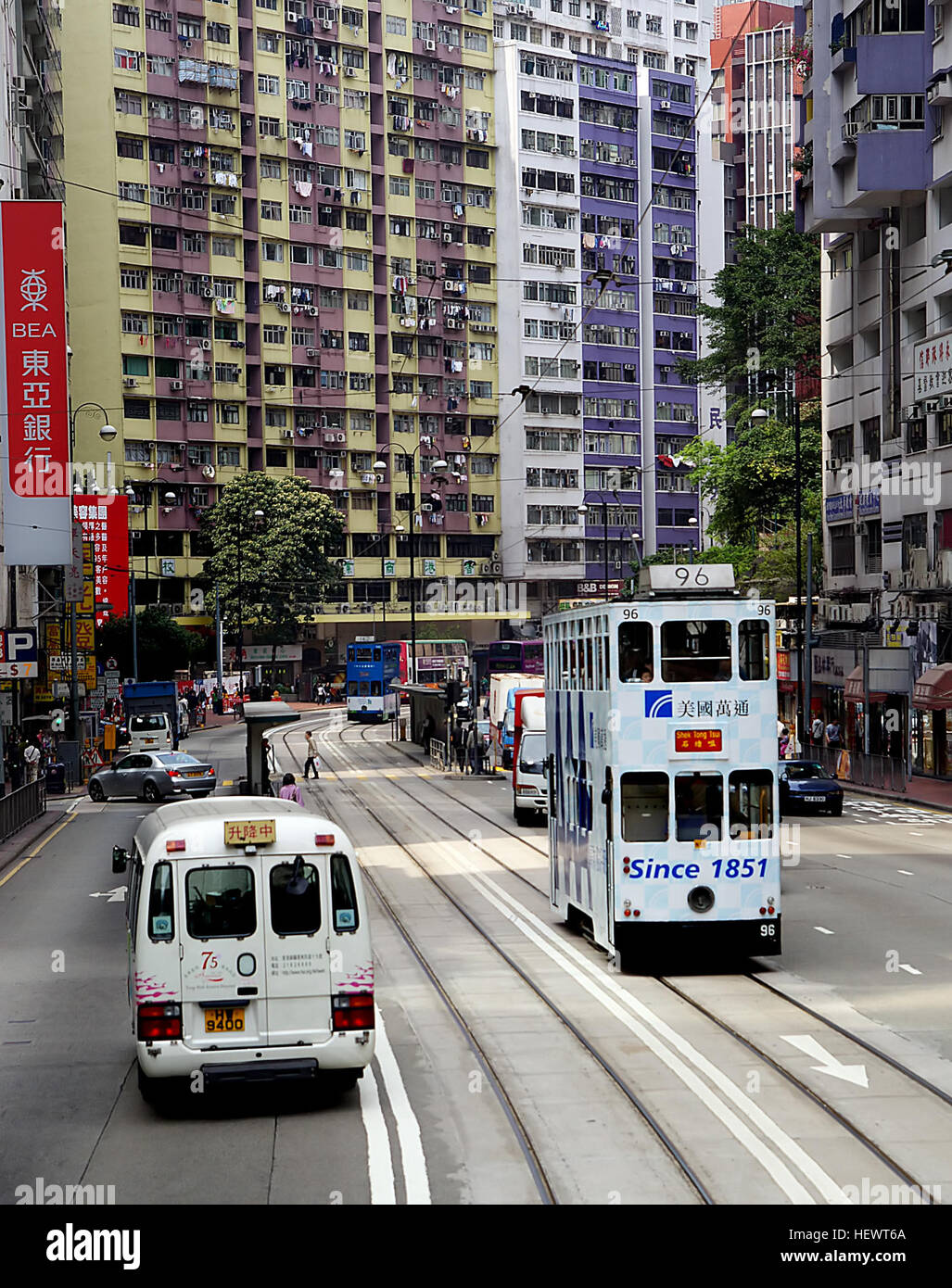 Eine fotografische Darstellung von Hongkongs pulsierendem Straßenleben mit den berühmten Straßenbahnen der Stadt. Diese Straßenbahnen haben sich zu einem bedeutenden Teil der Stadtlandschaft und zu einer beliebten Touristenattraktion entwickelt. Stockfoto