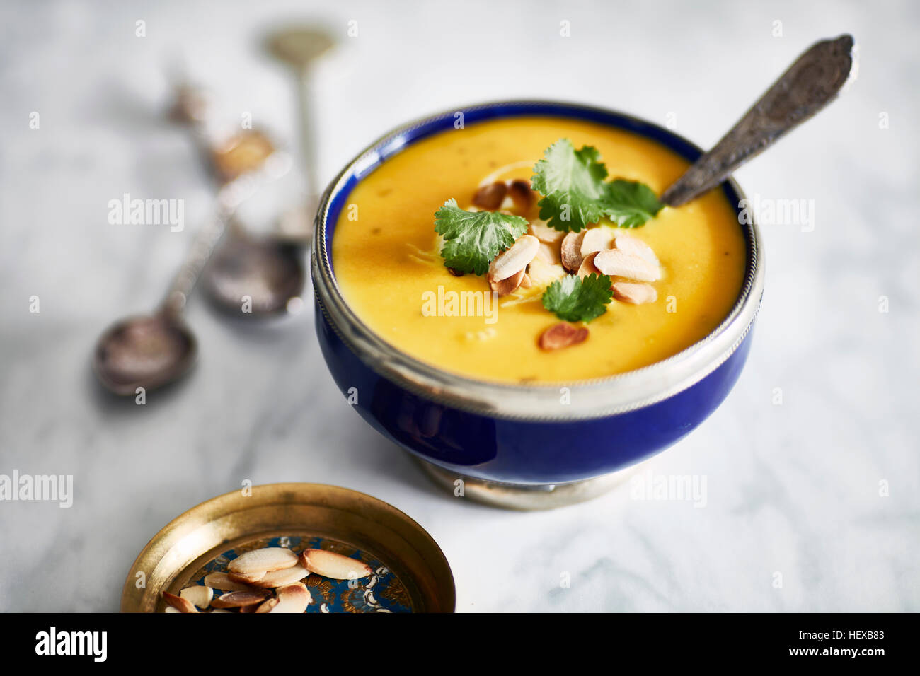Butternut-Kürbis-Suppe, garniert mit gerösteten Mandeln und Petersilie Stockfoto