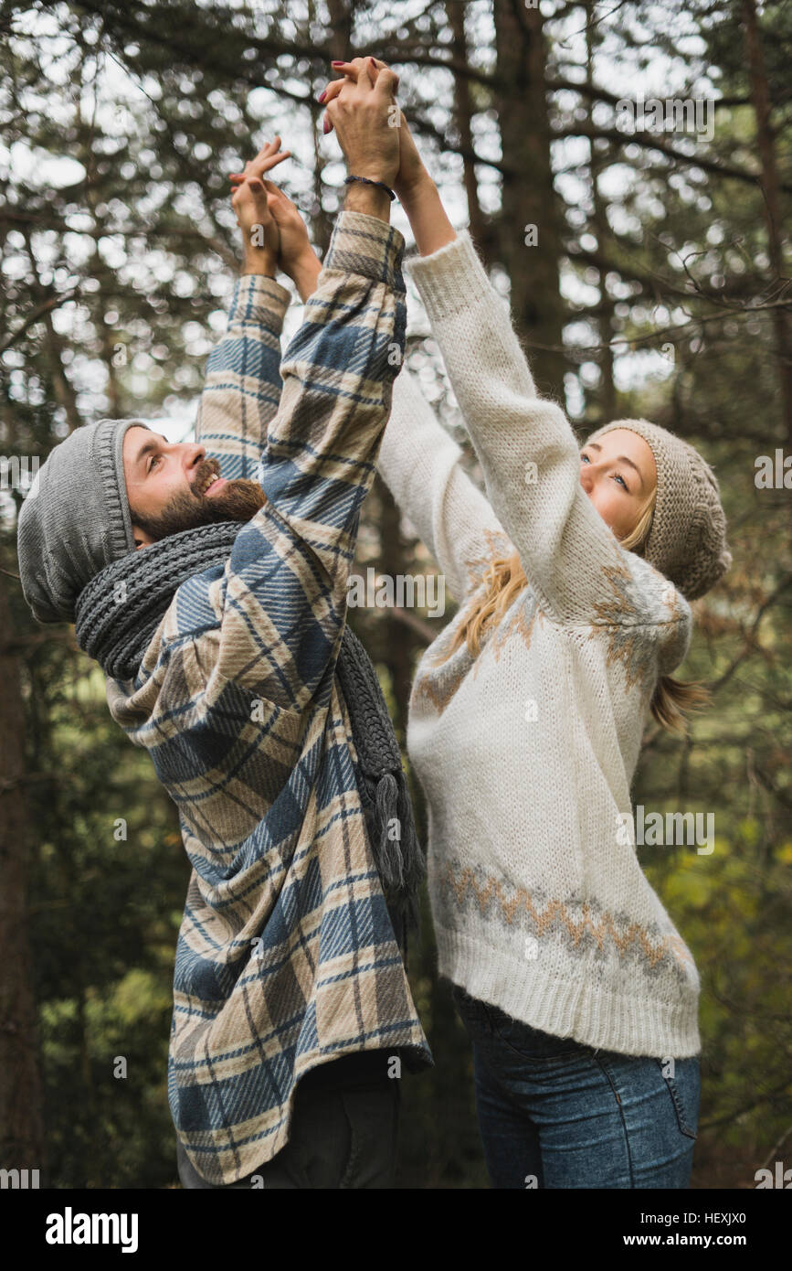 Glückliches junges Paar heben ihre Arme zusammen Stockfoto