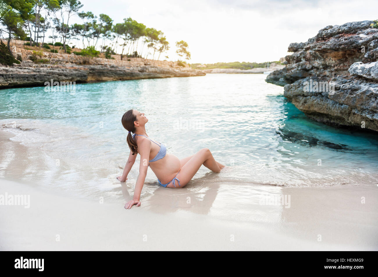 Schwangere Frau sitzen am Meer Stockfoto