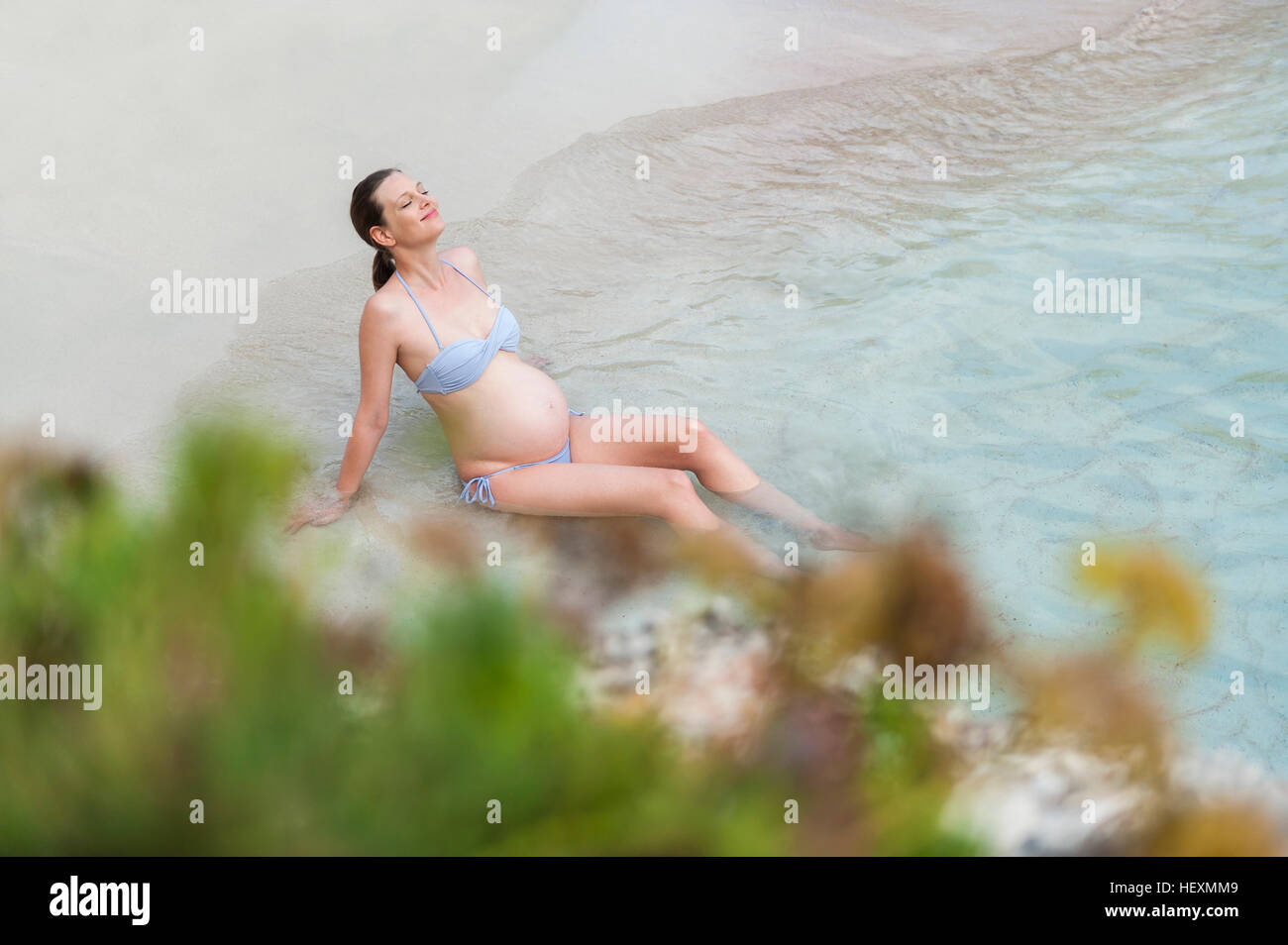 Schwangere Frau sitzen am Meer Stockfoto