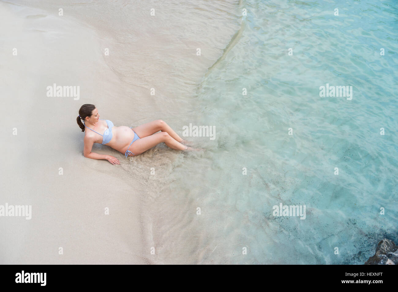 Schwangere Frau sitzen am Meer Stockfoto