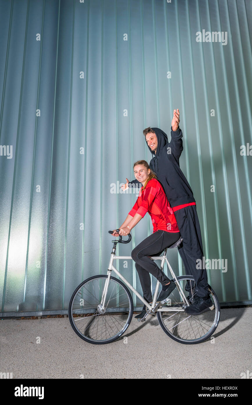 Junge Frau und Mann tut Kunstradfahren Stockfoto