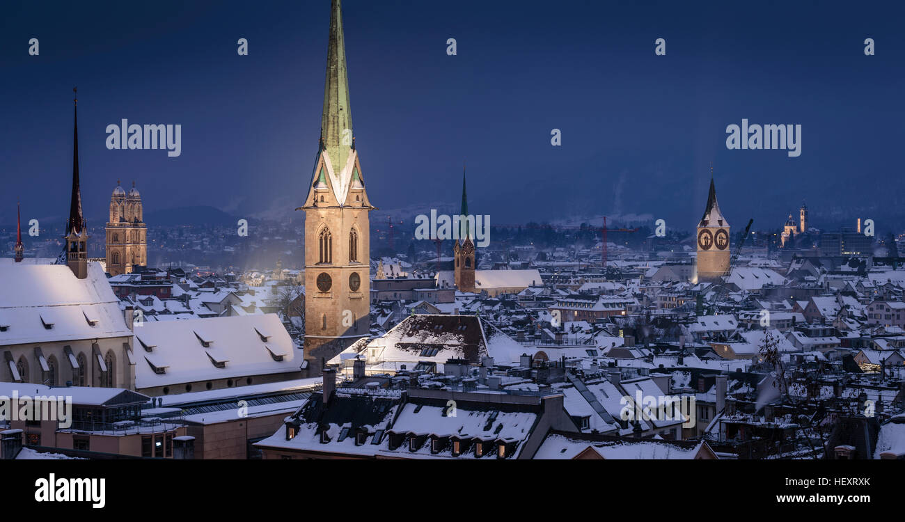 Die Altstadt mit Schnee bedeckten Dächer in der Nacht mit dem beleuchteten gotischen Glockentürme, Zürich, Schweiz. Stockfoto