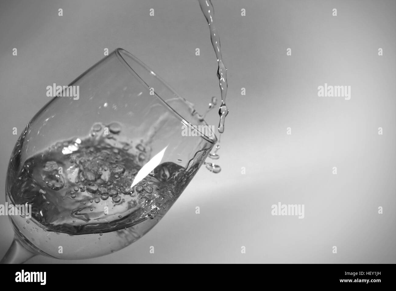 Kurze Verschlusszeit der Wasserfüllung ein gekippter Weinglas. Stockfoto