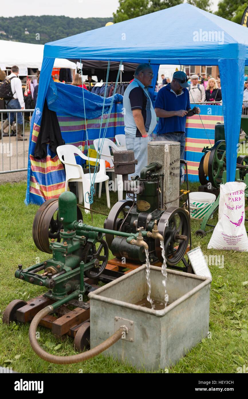 Ein Stationärmotor treibt eine Pumpe, die Wasser in einem Tank bei einer county Show pumpt. Stockfoto