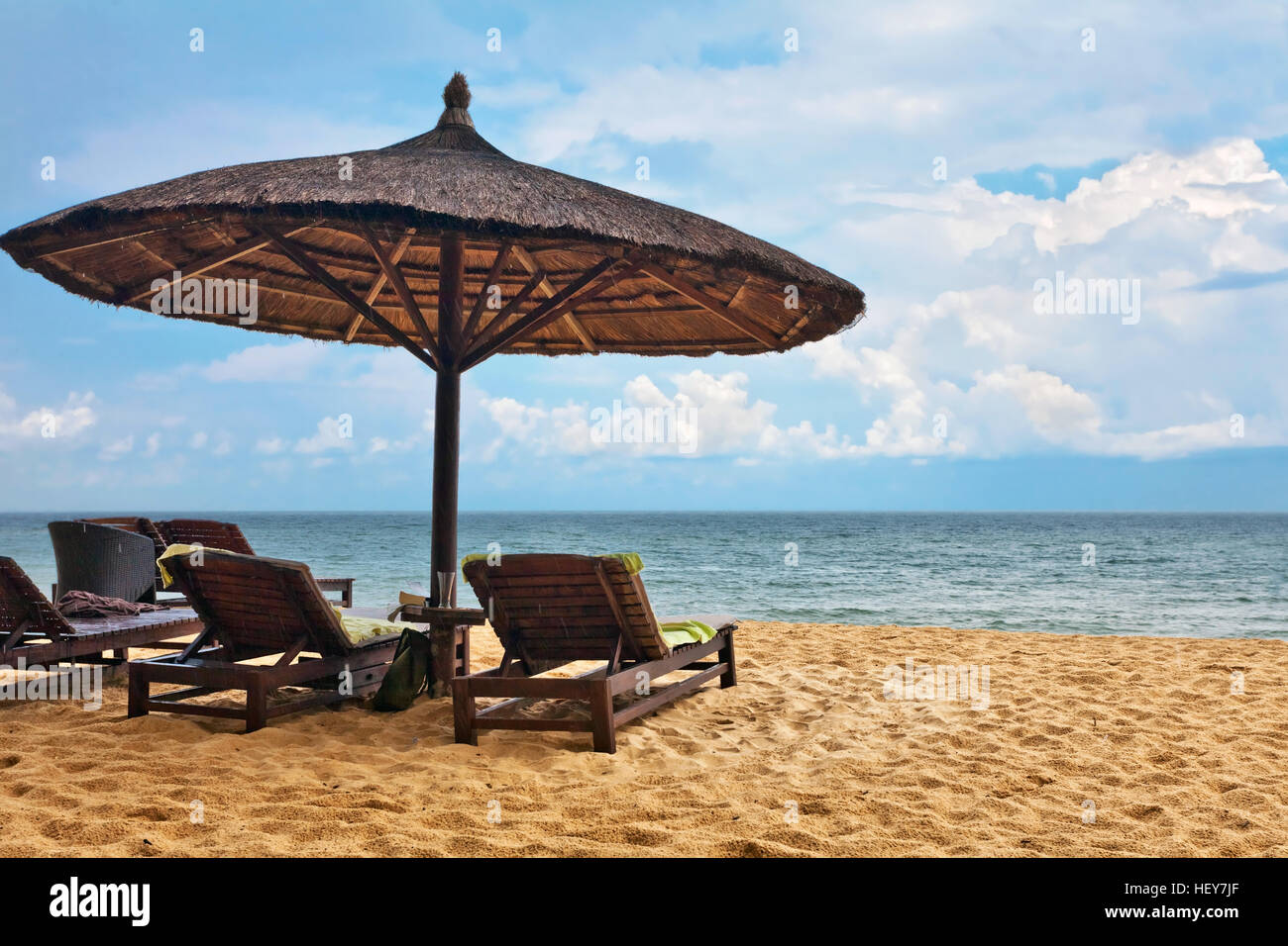 Hölzerne Stühle und Sonnenschirme am weißen Sandstrand auf der Insel Phu Quoc in Vietnam Stockfoto