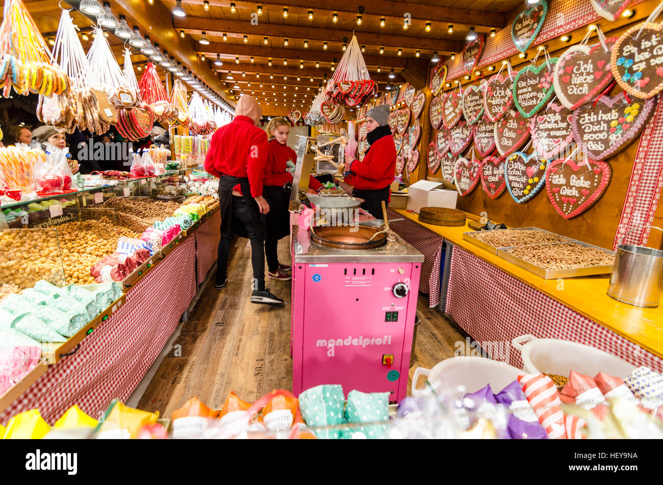 Menschen, die an einen Süßigkeiten-Stand auf einen deutschen Weihnachtsmarkt am Alexanderplatz, Berlin. Stockfoto