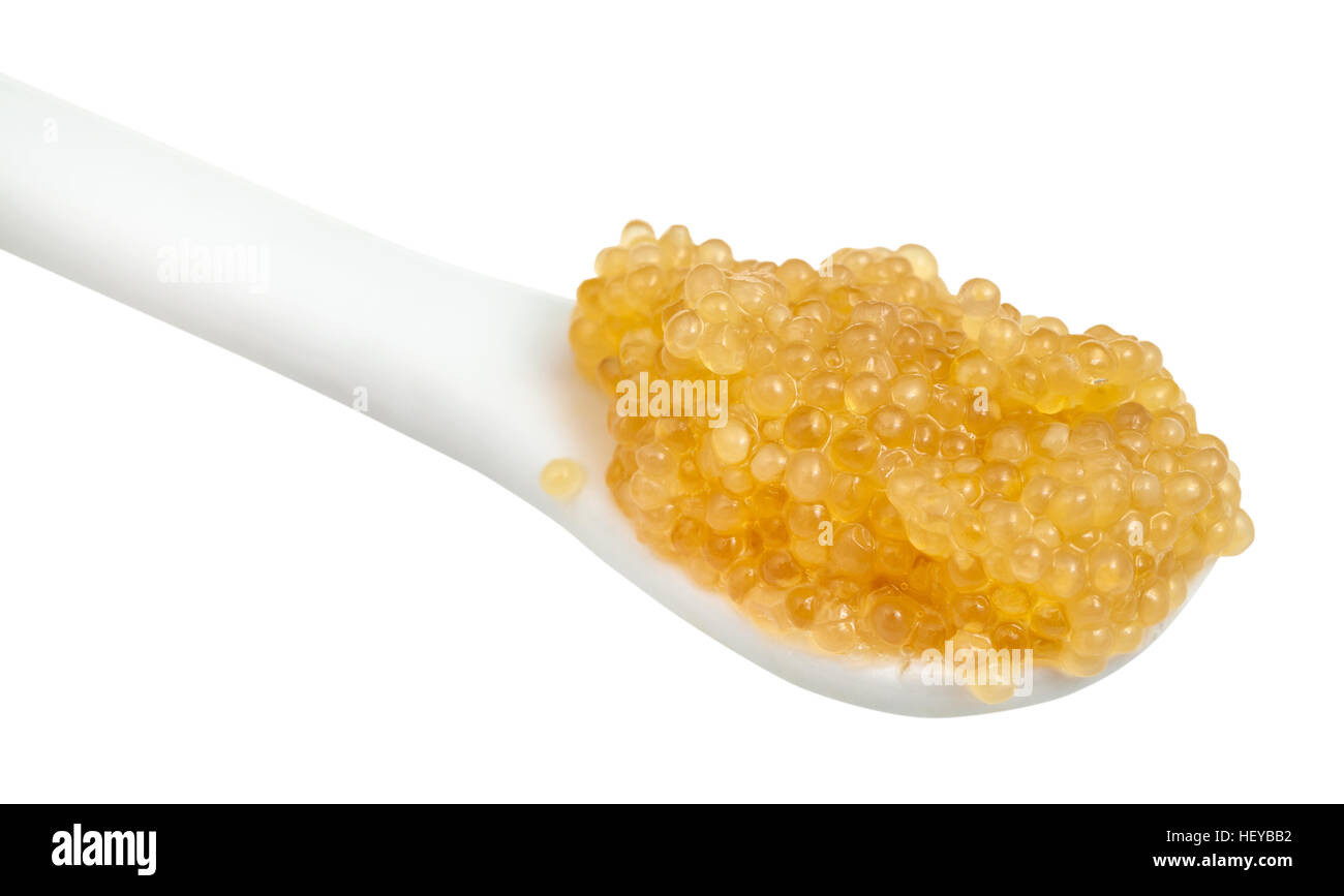 salzige gelben Kaviar Hecht Fisch in Keramik Löffel Nahaufnahme isoliert auf weißem Hintergrund Stockfoto