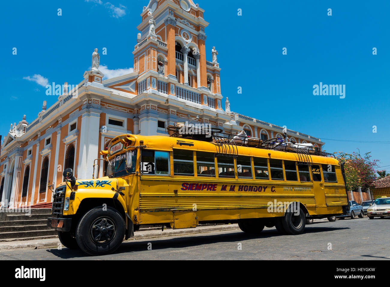 Granada, Nicaragua - 4. April 2014: Bus vor einer Kirche in einer Straße von der Kolonialstadt Granada in Nicaragua Stockfoto Granada, Nicaragua - 4. April 2014: Bus vor einer Kirche in einer Straße von der Kolonialstadt Granada in Nicaragua Stockfoto