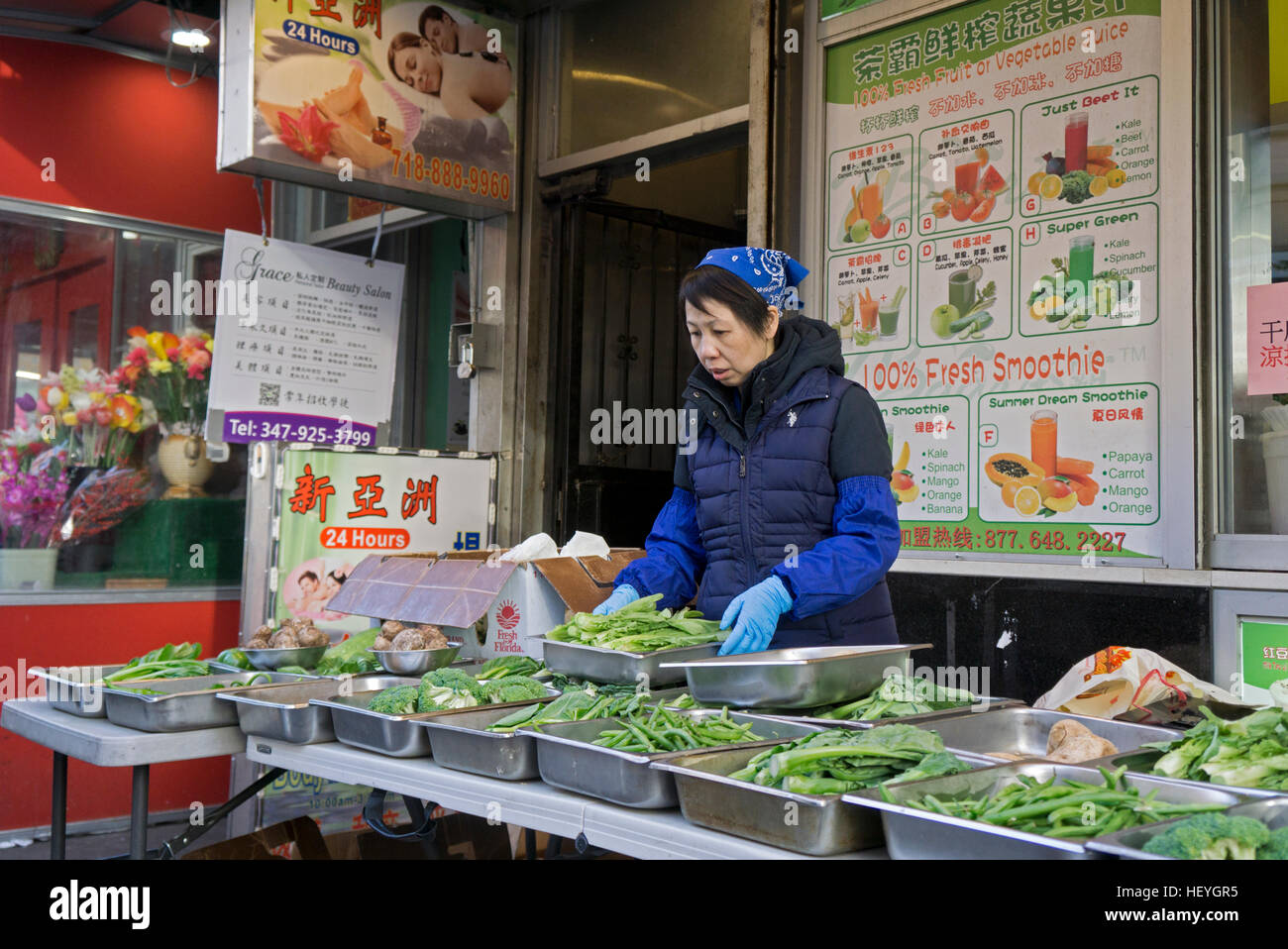 Eine Chinesin Gemüse & Säfte an einem Outdoor-Stand im Winter in CHinatown, Downtown Flushing, New York City zu verkaufen Stockfoto