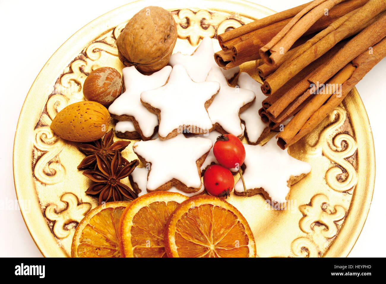 Weihnachtsteller: Zimtstangen, sternförmige Zimt Cookies, Sternanis, getrocknete Orangenscheiben, Hagebutten und Nüssen Stockfoto