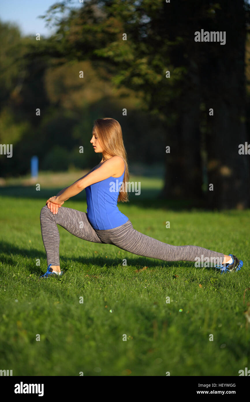 Schönes Mädchen streckt die Beine in den park Stockfoto