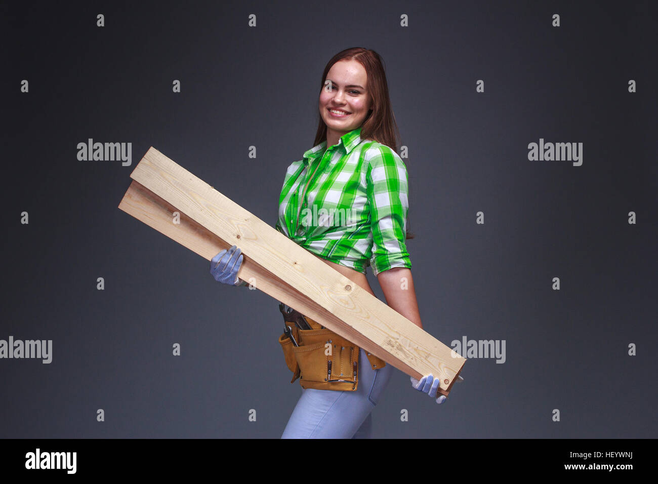 Hübsche Zimmermann Arbeiter mit Holzbrettern auf arm Stockfoto