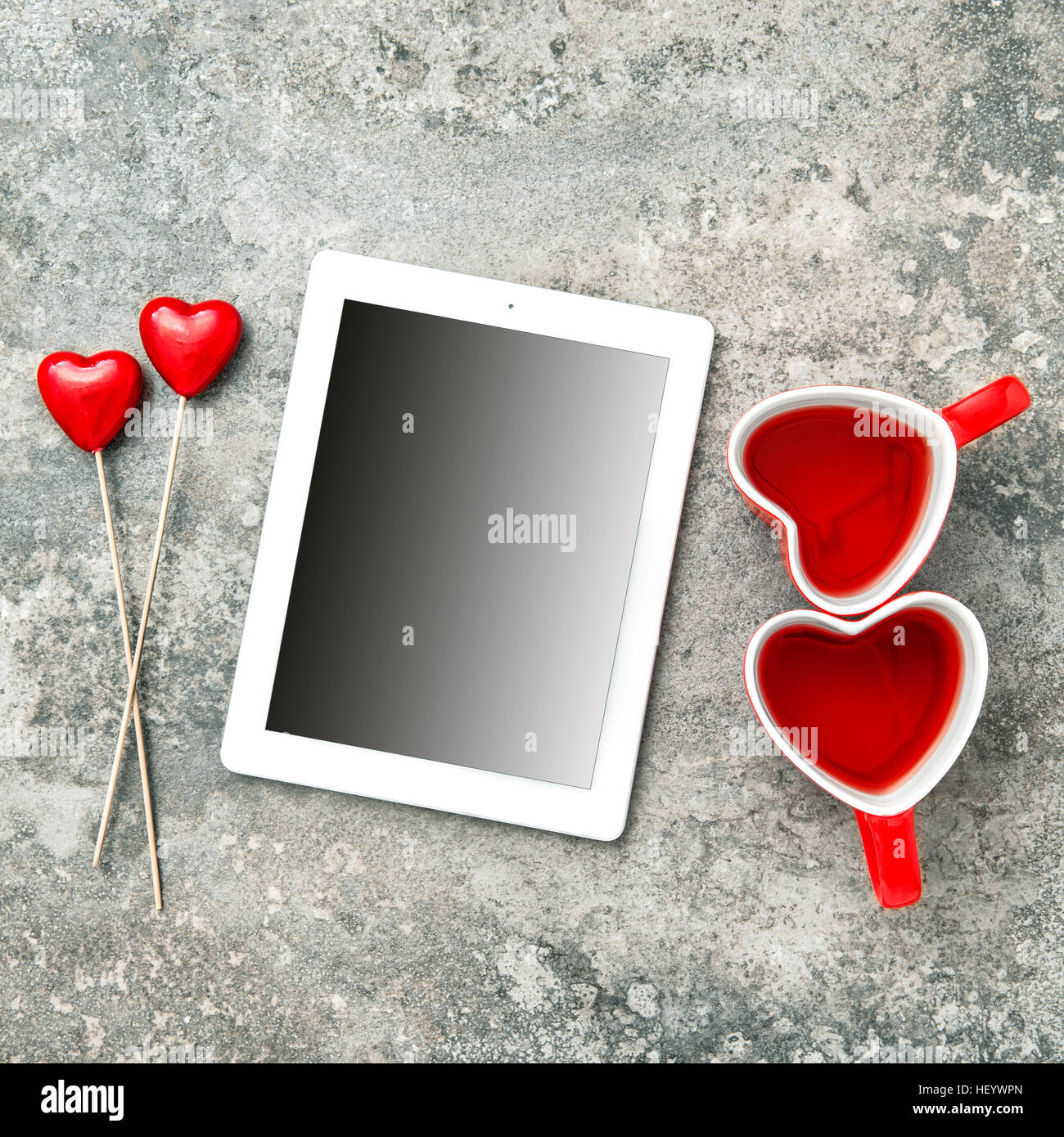Tablet-PC mit roten Herzen und Teetassen. Valentinstag Dekoration Stockfoto