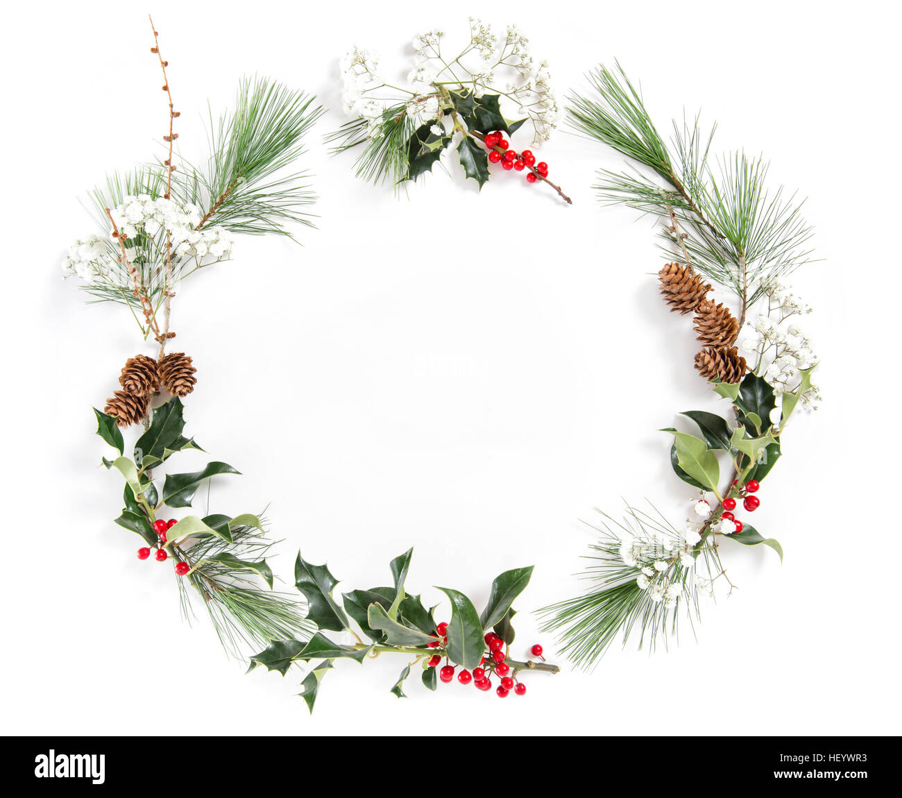 Rahmen aus Kiefer Äste mit Ilex hinterlässt auf weißem Hintergrund. Weihnachten Blumen flach legen Stockfoto