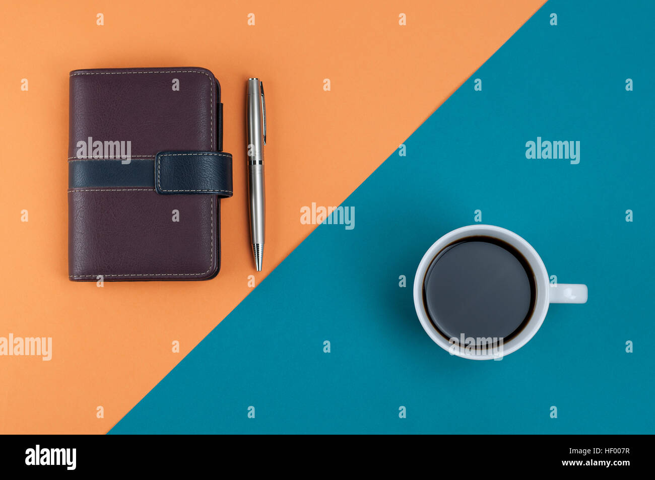 Hinweis Buch Stift und Kaffee auf Orange Kreuz Pastell hellblauen Hintergrund, Draufsicht, flach lag. Stockfoto