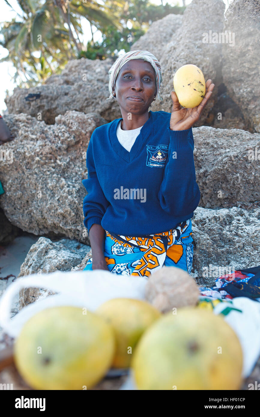 Weibliche Obstverkäufer mit Mango in ihrer Hand, 34 Jahre alt, Bamburi Beach, Mombasa, Mombasa County, Kenia Stockfoto