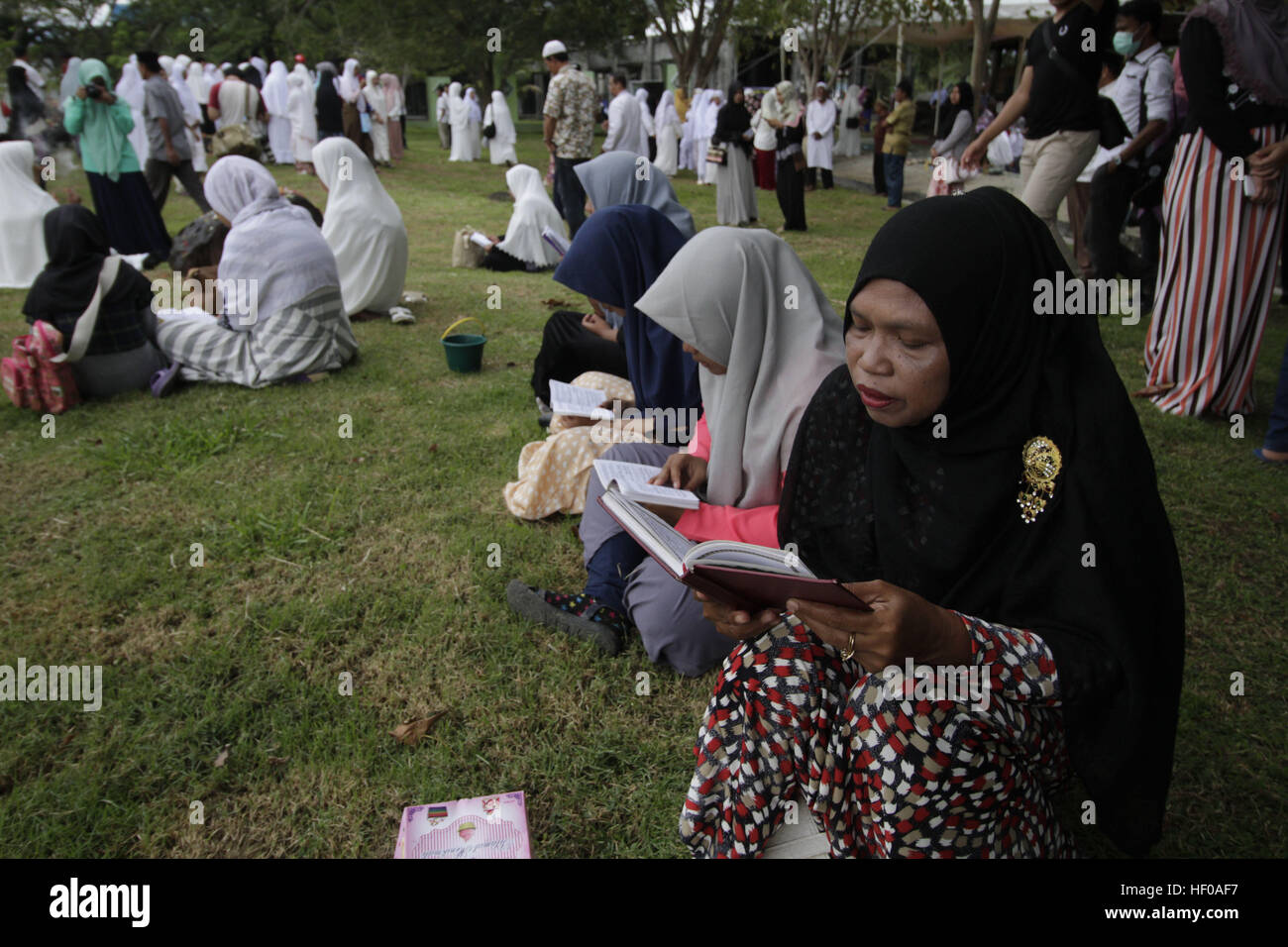 Aceh, Indonesien. 26. Dezember 2016. Die Menschen beten an einem Masse Friedhof, wo Tausende von 2004 Tsunami-Opfer während der Gedenkfeier zum 12. Jahrestag des verheerenden Tsunamis auf Ulee Lheue in Aceh, Indonesien, 26. Dezember 2016 begraben sind. Dezember dieses Jahres ist der 12. Jahrestag des Tsunami im Indischen Ozean, die wurde durch ein Erdbeben der Stärke 9,1 auf 26. Dezember 2004 und mehr als 230.000 Menschen getötet. © Junaidi/Xinhua/Alamy Live-Nachrichten Stockfoto