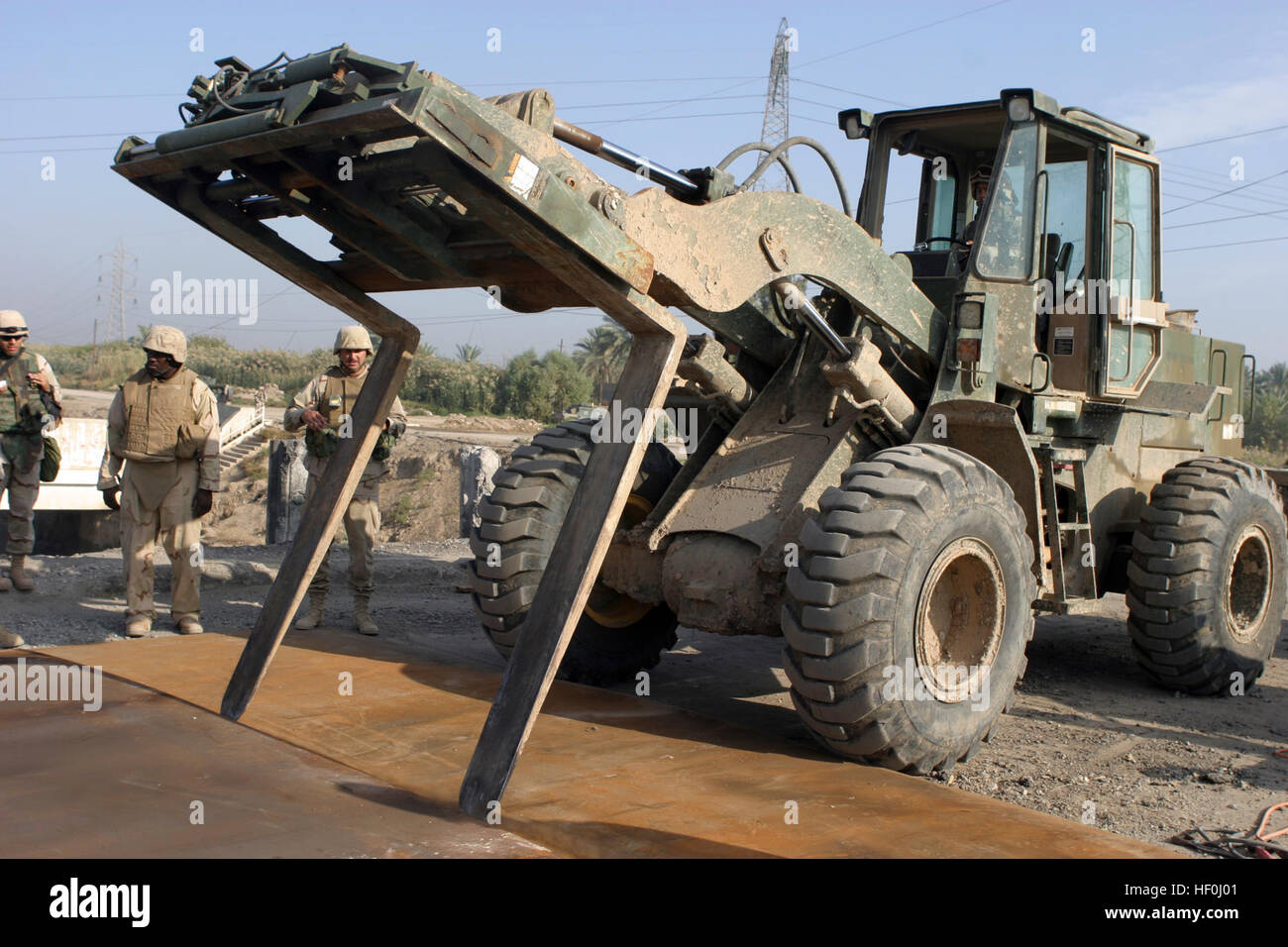 041116-M-1250B-013 Mahmuydiyah, Irak (16. November 2004) - A Seabee zugewiesen Naval Mobile Bau-Bataillon vier (NMCB-4), Kalsu Ablösung, betreibt ein Gabel-Leben, wie es große Stücke aus Blech über einem Impaktkrater schiebt, wie NMCB-4 eine Brücke in Mahmuydiyah, Irak rekonstruiert. Die Brücke wurde im wiederholten Angriffe von Aufständischen schwer beschädigt. NMCB-4 ist derzeit auf der 24. Marine Expeditionary Unit (MEU) zugewiesen, die Sicherheit und Stabilisierungsoperationen in Babil Provinz Nordirak durchführt. US Marine Corps Foto von Lance Cpl. Sarah A. Biber (freigegeben) US Navy 041116-M-1 Stockfoto