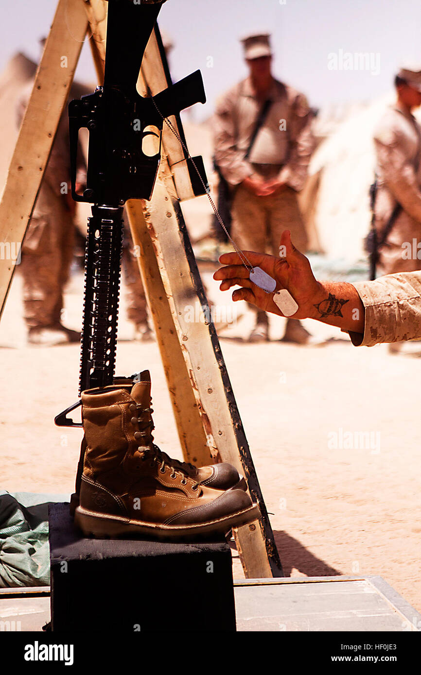 GARMSIR DISTRICT, Provinz Helmand, Afghanistan – A Marine mit Charlie Kompanie, 1. Bataillon, 3. Marineregiment zollt Respekt, CPL Nicholas S. Ott während einer Trauerfeier am Combat Outpost Rankel hier, 17. August. Die Trauerfeier war Ott gleichzeitiger Unterstützung der Aufstandsbekämpfung hier verstorbenen Aug. 10. Ott, gebürtig aus Manchester, N.J., war ein Squad-Leader mit 3rd Platoon, Charlie Kompanie. Denkmal zu Ehren der gefallenen 110817-M-ED643-016 Stockfoto