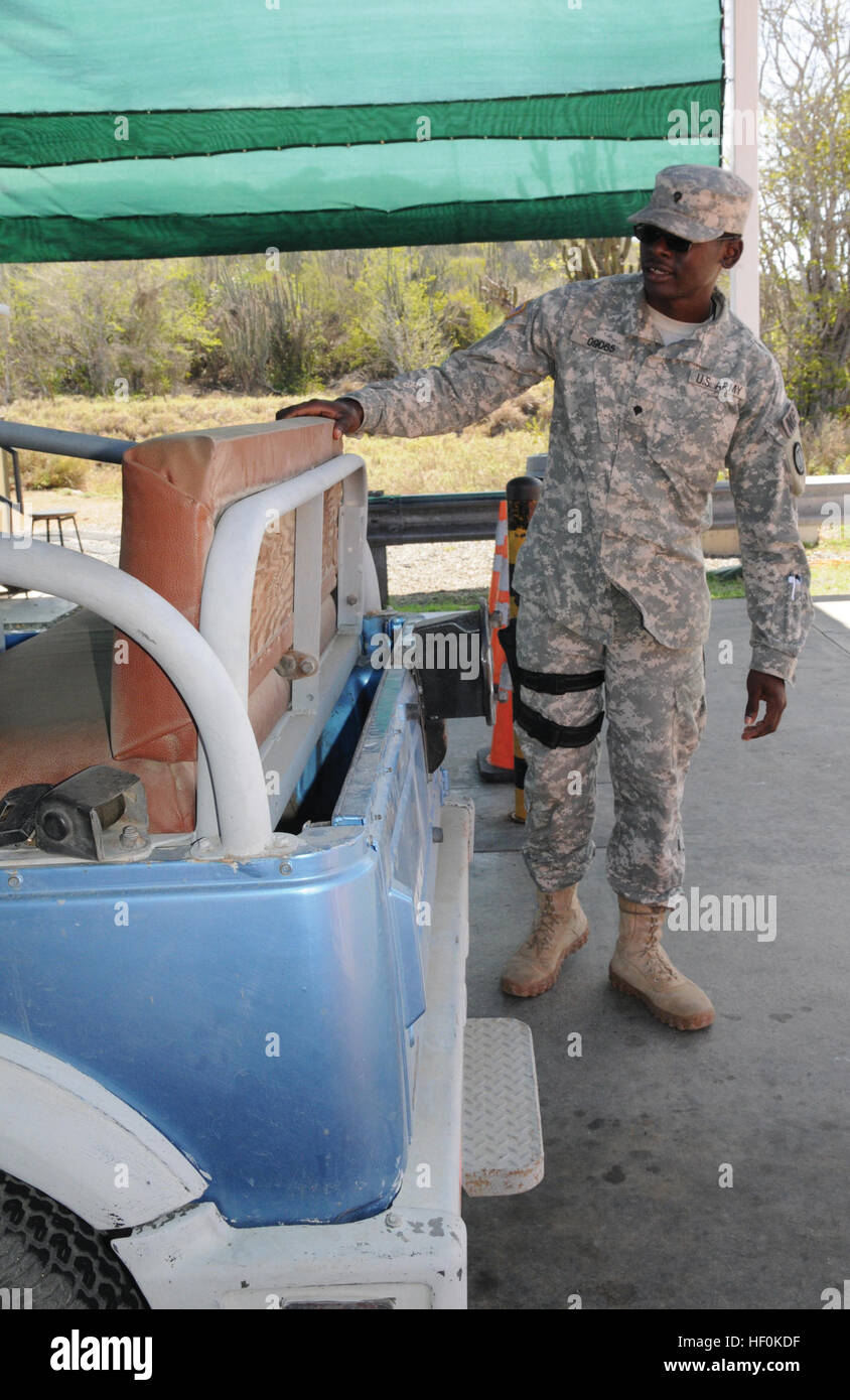 Armee Spc. Gregory Hyde, ein Militärpolizist zugewiesen der 128. Military Police Company, prüft ein Fahrzeug bei Joint Task Force Guantanamo Roosevelt Sicherheitskontrolle, US Naval Station Guantanamo Bay, Kuba, 12. August 2013.  (Army National Guard Foto von Spc. Lerone Simmons/133rd MPAD/JTF Guantanamo Public Affairs) An der Pforte 130812-Z-IB888-029 Stockfoto