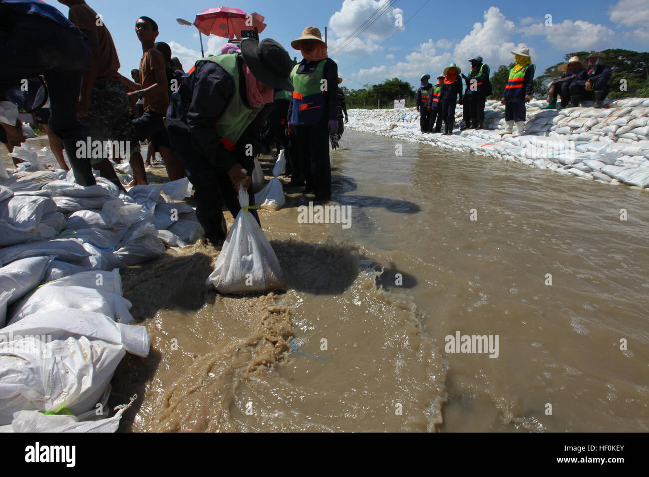 Freiwilligen und Mitgliedern der Royal Thai Army, Militärpolizei, Füllung und Ort Sandsäcke umleiten Überschwemmungen im Bezirk Nord Sai Mai durch den Khlong Hok Wa-Kanal während einer Boden-Flut-Bewertung durch die III. Marine Expeditionary Force humanitäre Hilfe Umfrage Team nördlich von Bangkok, Thailand, 25. Oktober 2011. Die HAST prüft Schäden durch Überschwemmungen in Thailand und keine Unterstützung für humanitäre Hilfe und/oder Disaster Relief III MEF könnte. Royal Thai Armed Forces verstärken den Bereich mit einem Sandsack-Wand, die Strömung von Wasser umzuleiten. Einundsechzig Provinzen und 8,2 Millionen Stockfoto