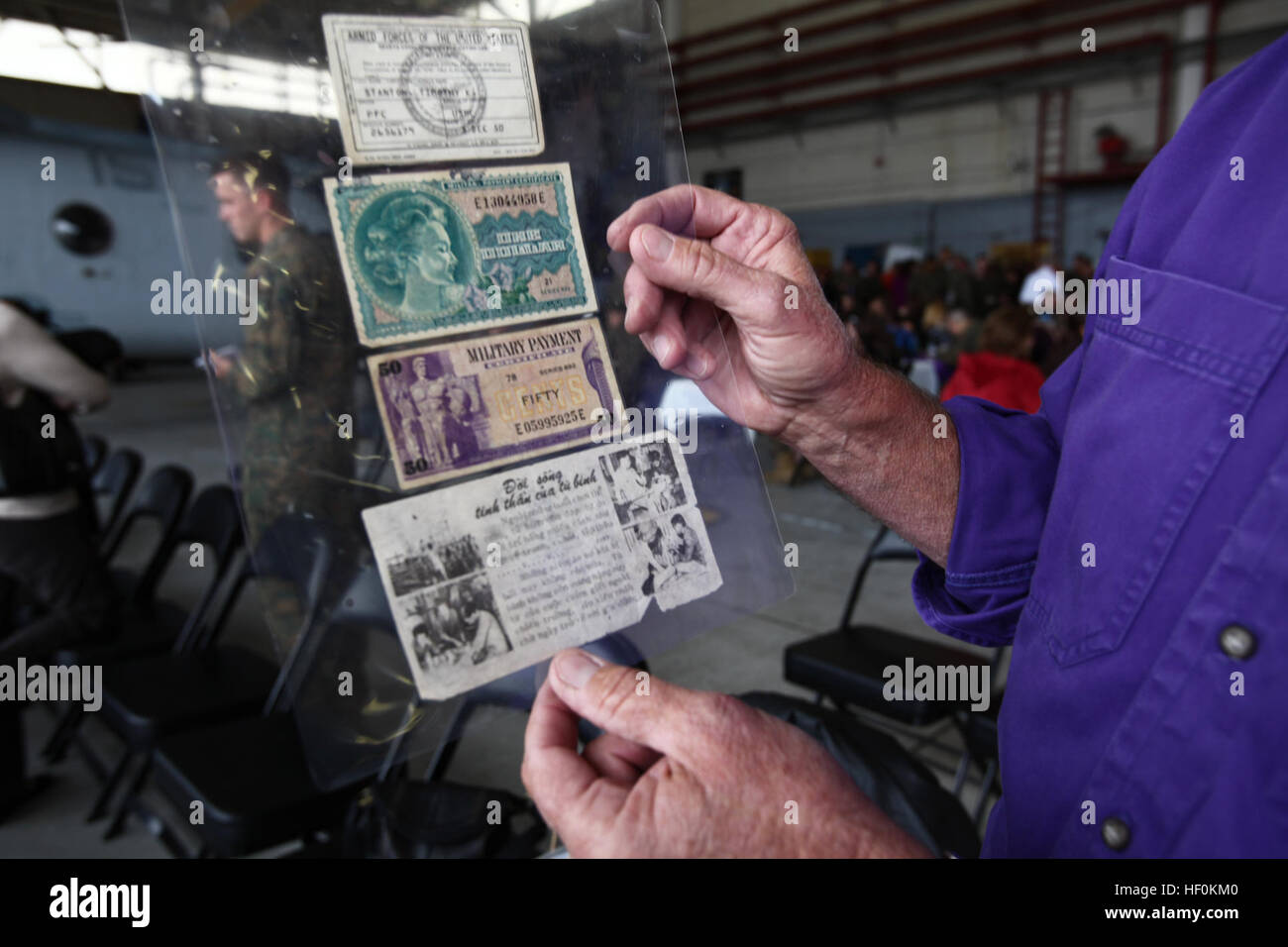 Tim Stanton, San Gabriel, Kalifornien, native und ehemalige Marine, zeigt $1,50 in "militärische Geld", eine Karte der Genfer Konventionen und eine amerikanische Propaganda-Broschüre bei der 50. Jahrestag Feier für Marine Medium Helicopter Squadron 364 an Bord der Marine Corps Air Station Camp Pendleton, Kalifornien, November 10. Stanton hatte diese Elemente in den Hosentaschen, wenn er medizinisch aus Vietnam im Jahr 1971 durch die HMM-364 lila Füchse evakuiert wurde. Lila Füchse feiern Ende der OIF, 50. Jahrestag 111110-M-NF414-386 Stockfoto