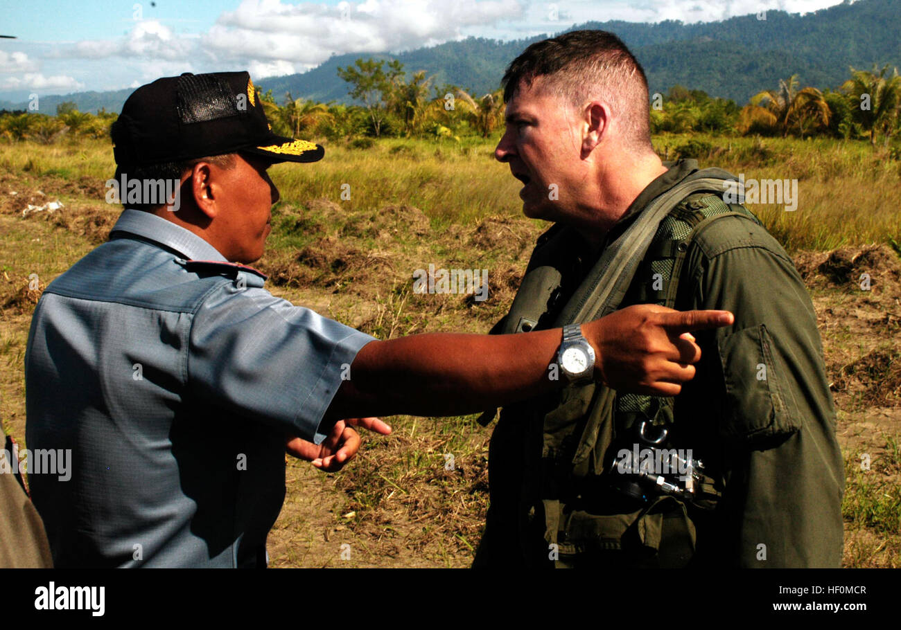 BLANG PIDIE, Indonesien (9. Januar 2005)--Generalmajor Ron Carson, 38, CH-53E Pilot mit Marine Medium Helicopter Squadron 165 (Lauf) zu Trikoria, eines Vertreters der indonesischen Regierung über eine Kraftstoffversorgung hier spricht. Die 15. Marine Expeditionary Unit bietet dringend benötigten humanitären Hilfe für Städte und Dörfer entlang der westlichen Küste von Sumatra mehr als 150 Meilen.  (Foto von Gunnery Sgt. Robert Knoll) USMC-050109-M-8664K-144 Stockfoto