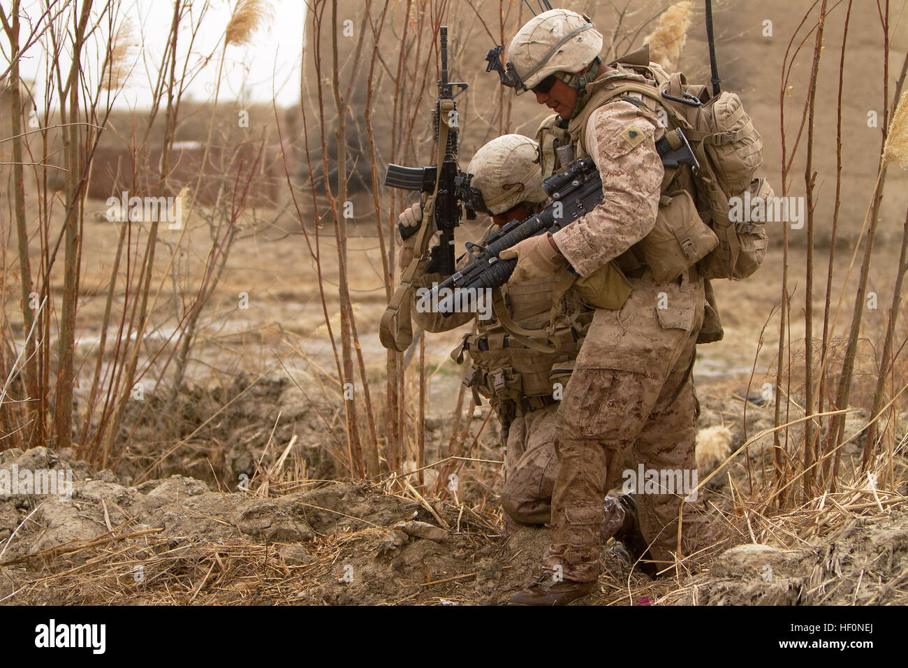 US Marine Sgt. Mario Mendoza, Teamleiter mit Alpha Company, 1st Light Armored Reconnaissance Battalion und 25 Jahre alte gebürtige Seguin, Texas, hilft Lance Cpl. Marcos Castelan, ein leicht gepanzertes Fahrzeug Besatzungsmitglied mit Alpha Co., 1. LAR und 19-Year-Old Eingeborener von Alvin, Texas, aus einem Kanal während einer Patrouille hier 16 Februar. Space-Marines und Segler mit 1. LAR und Indien Co., 3. Bataillon, 3. Marine Regiment, durchgeführt clearing und Betriebsunterbrechungen in und rund um die Dörfer von Sre Kala und Paygel während der Operation Highland Donner. Marines mit 1. LAR führte die Operation zu Fuß, fegen fo Stockfoto