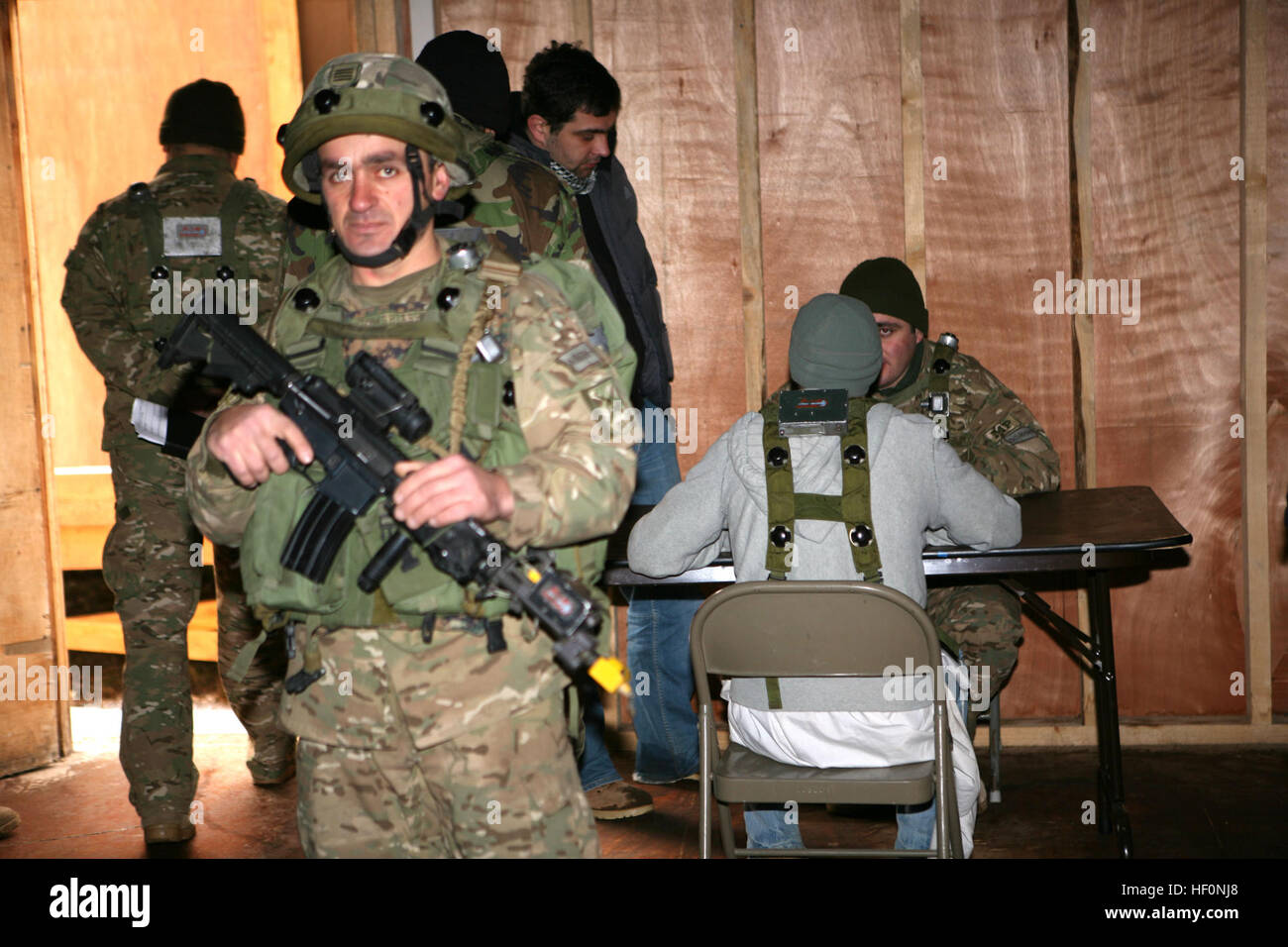 Ein georgischer Soldat von Charlie Kompanie, 23. Light Infantry Battalion, bietet Sicherheit, während andere Einheit Mitglieder einer mutmaßlichen Aufständischen Frage, die während einer Kordon und Suche Operation während einer Mission Probe Übung auf gemeinsame Multinational Readiness Center Hohenfels, Deutschland, 20 Februar festgenommen wurde. Der 23. Infanterie-Bataillon georgischen Licht bereitet Aufstandsbekämpfung in Afghanistan als Teil von Georgien Deployment Program - International Security Assistance Force zu unterstützen. Marines beobachten GeorgianE28099s Charlie Kompanie 23. LIB raid feindlichen Aufständischen auf Probe mögens- Stockfoto