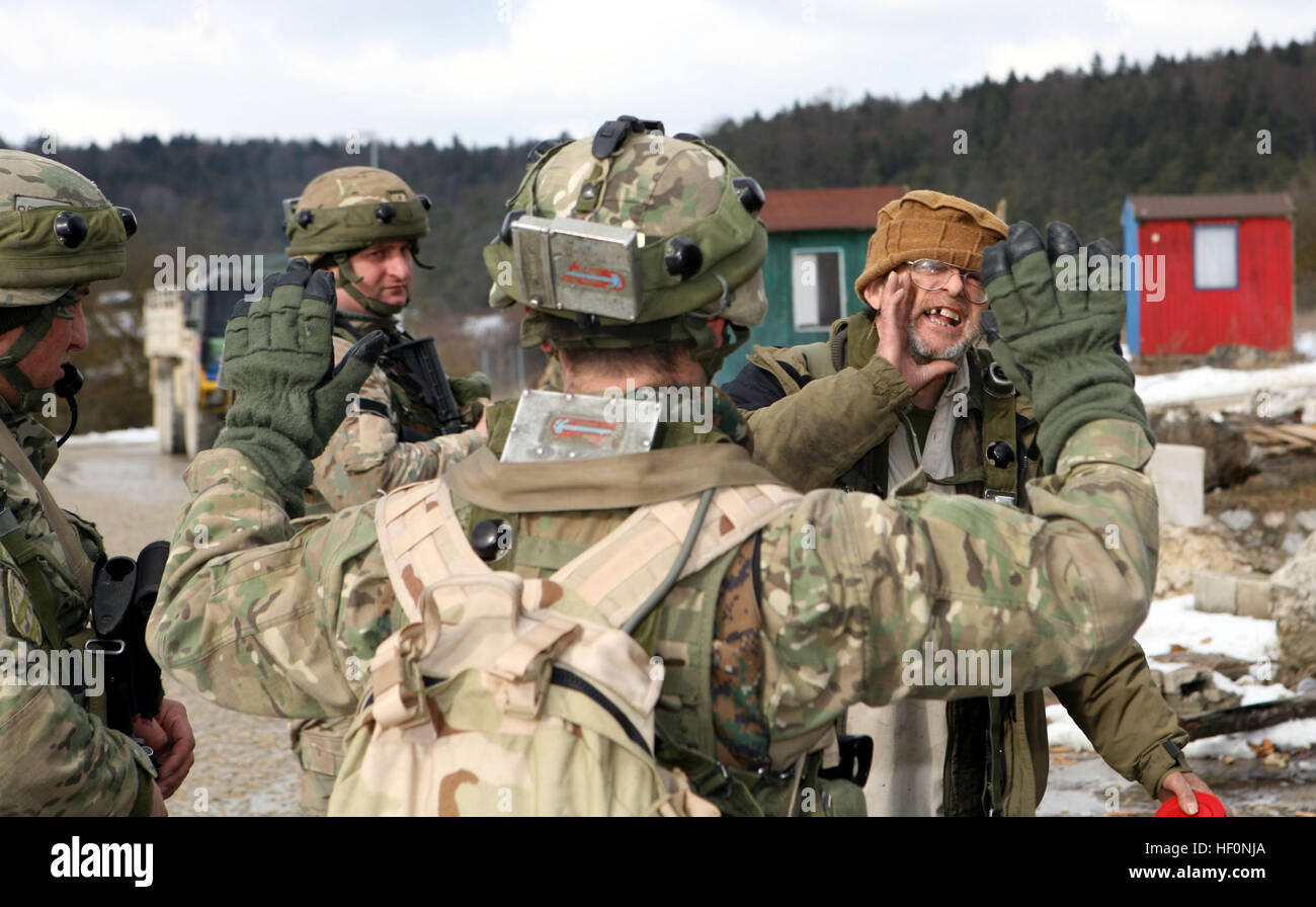 Georgische Soldaten versuchen, eine lokale Dorfbewohner beruhigen, die aufgeregt, während Charlie Kompanie, 23. Licht Infanteriebataillon Patrouille von dem Dorf in der Nähe ihrer Bekämpfung Außenposten im Joint Multinational Readiness Center Hohenfels, Deutschland für eine zufällige Suche gefangen gehalten wurde. Der 23. Infanterie-Bataillon georgischen Licht steht JMRC Durchführung einer Mission Probe Übung in Vorbereitung zur Aufstandsbekämpfung in Afghanistan als Teil von Georgien Deployment Program - International Security Assistance Force zu unterstützen. Marines beobachten GeorgianE28099s Charlie Kompanie 23. LIB raid feindlichen Insurgen Stockfoto