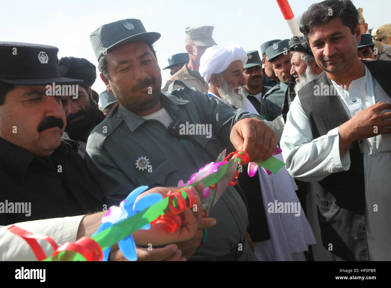 Nawa District Chief der Polizei Ahmed Sha, Center, schneidet das Band während der feierlichen Eröffnung von der neuen afghanischen lokalen Polizei (ALP) Komplex in der Nähe von combat Outpost Jaker, Provinz Helmand, Afghanistan, 26. März 2012. Die ALP Komplex wird als eines der Polizeistationen im Stadtteil dienen. (US Marine Corps Foto von CPL. Nicholas J. Gillen / veröffentlicht) Eröffnung der afghanischen Polizei komplexe 120326-M-OM313-098 Stockfoto