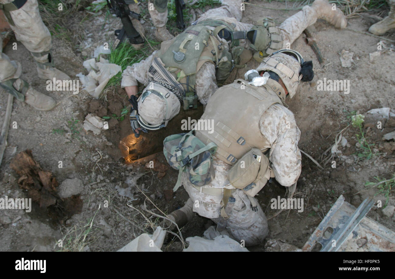 Bagdad, Irak--(19. März 2005) - zwei Marines von Bravo Co. mit Battalion Landing Team 1/1, 15. Marine Expeditionary Unit (spezielle Operationen fähig), suchen ein verdächtiges Loch entdeckt während einer Patrouille in einem Bauerndorf in Bagdad. Das 15. MEU (SOC) führt Sicherheit und Stabilisierung Operationen im Bereich größerer Bagdad. USMC-050324-M-5538E-112 Stockfoto