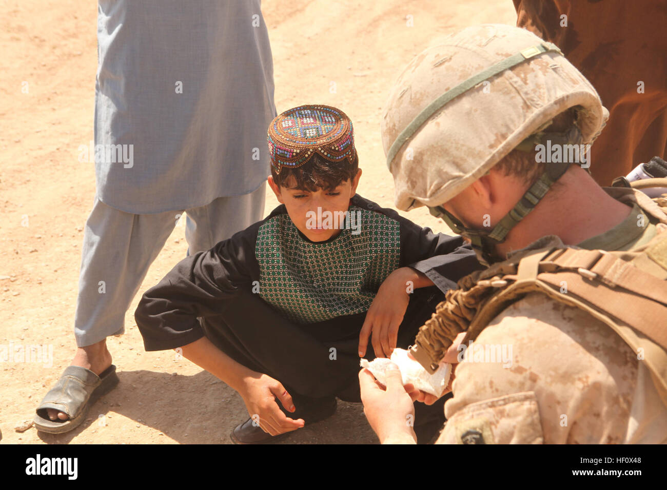 U.S. Navy Hospital Corpsman drittklassigen Samuel Pentowski mit Polizei Advisory Team (PAT), Ostindien-Kompanie, 3D Battalion 8th Marine Regiment, Regimental Combat Team 5 bietet medizinischen Hilfe zu einem lokalen afghanischen jungen bei einer Routinekontrolle logistische mit afghanischen Uniformierte Polizei (AUP) im Marjeh District, Provinz Helmand, Afghanistan 1. Juli 2012. Die PAT besucht dem Bahnhof Check ihre Logistik-Kapazitäten. (U.S. Marine Corps Foto von Lance Cpl. Cesar N. Contreras/freigegeben) AUP Logisitics Check in Marjeh Bezirk 120701-M-PO905-066 Stockfoto