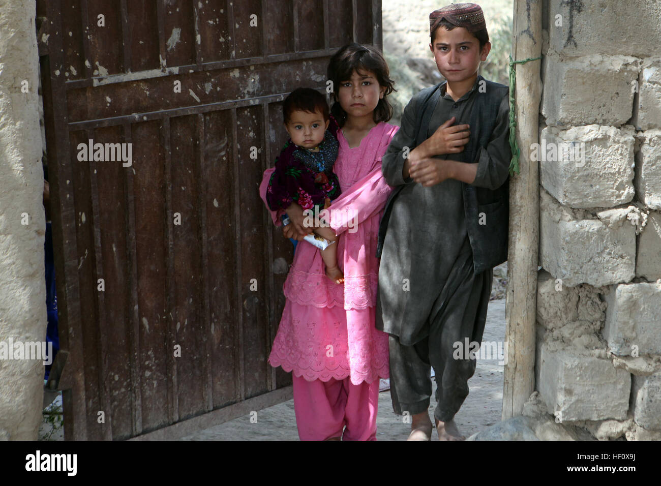 Afghanische einheimischen zusehen, wie Afghan National Army Soldaten, zusammen mit ihre Marine-Kollegen von Alpha Company, 1. Bataillon, 7. Marines, Regimental Combat Team 6, Patrouille vorbei an ihre Verbindung während der Operation Gospand-Sia im Bezirk Sangin Tal 11. Juli 2012. Die afghanisch-geführten Operation war geplant für 48 Stunden, aber ANSF mehrere Sprengsätze und ein Waffenlager zerstört und alle ihre Ziele in weniger als 16 Stunden gelöscht. Afghanen übernehmen Führung im Betrieb Gospand-Sia 120711-M-BZ222-003 Stockfoto