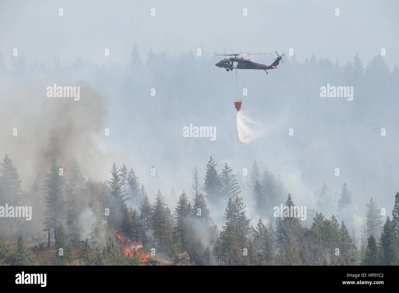 Ein US Army UH-60 Black Hawk Hubschrauber, Kalifornien Army National Guard Tropfen Wasser auf die Ponderosa Wildfire in der Nähe von Redding, Kalifornien, 23. August 2012 zugewiesen. California Air wurden Armee Nationalgardisten Brandbekämpfung Bemühungen unterstützt und in mehrere Teile des Staates. (Foto von David J. Loeffler Master Sgt.) California Waldbrände 2012 120823-Z-WQ610-012 Stockfoto