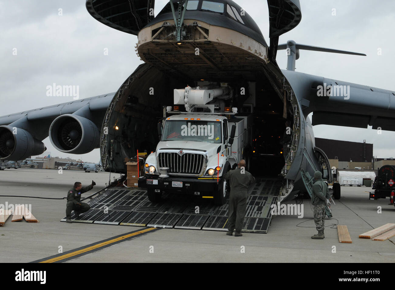 Travis zusammenarbeiten und 105. LRS Antenne Port Luft Gardisten entladen Begleitfahrzeug, der Energieversorger Southern California Edison aus einer Galaxie C-5 b angehören. Die Fahrzeuge in der 105. Airlift Wing inszeniert werden ausziehen Bemühungen zur Wiederherstellung von Kraft und humanitäre Hilfe in der betroffenen Region zu unterstützen. Teil der USNORTHCOM Verteidigung Unterstützung der Zivilbehörden Mission leitet den Befehl zu planen und zu Aktionen, die es eventuell erforderlich sind zur Unterstützung der zivilen Behörden zu antizipieren. USNORTHCOM spielt eine wichtige Rolle in der Katastrophenhilfe; Dennoch sind alle Bemühungen für Hurrikan Sandy Stockfoto