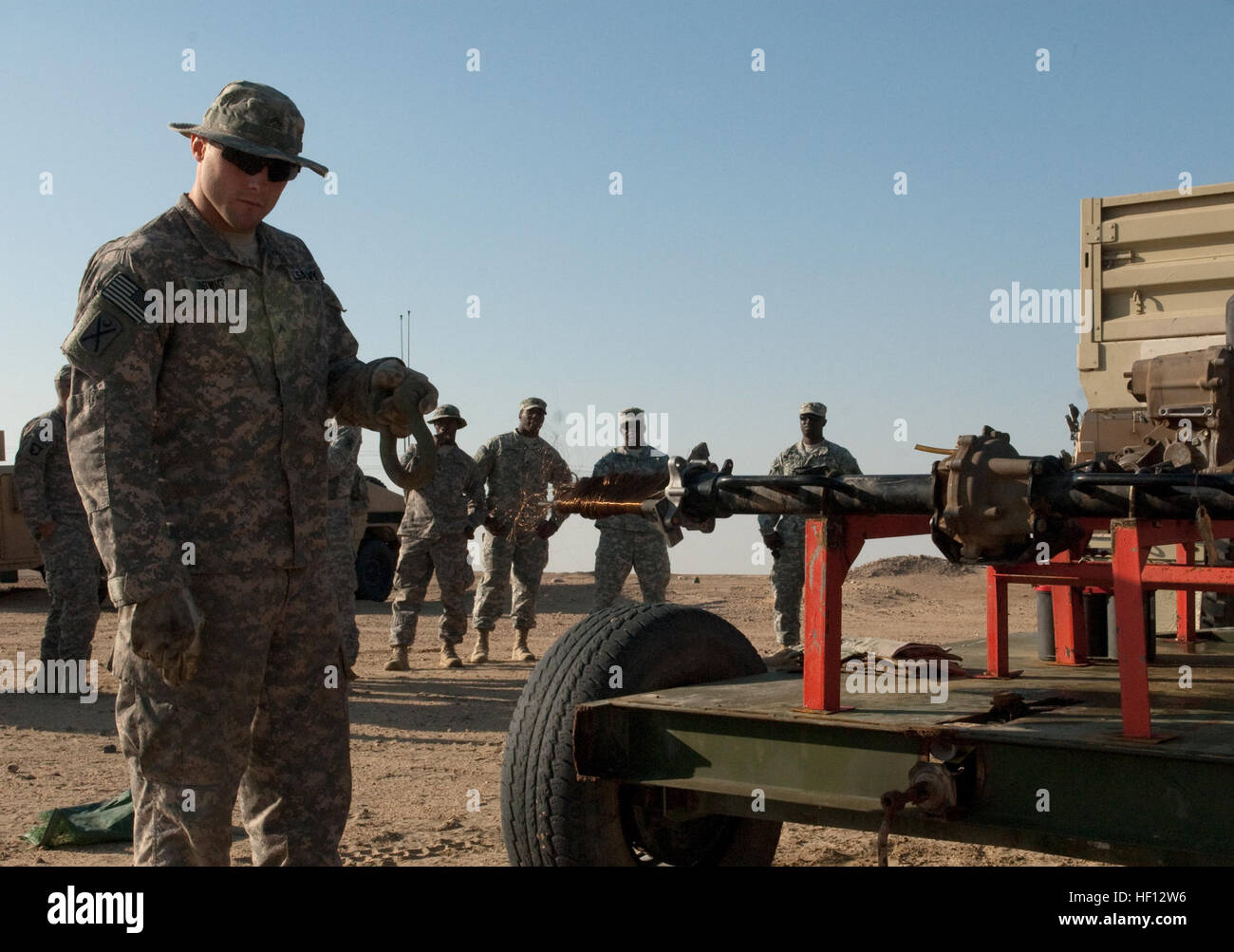 Mit einem Zugfahrzeug Schäkel, CPL Nicholas Orwig, 444th Chemical Company, Illinois Army National Guard, führt TOW-Raketen-Draht wie ein Motor es auf der Udairi-Range in der Nähe von Camp Buehring, Kuwait, November 27 spult. Soldaten der Delta Company, 4. Bataillon, Infanterie-Regiment 118. abgefeuert 16 Raketen an der Reihe, und 444th Chemical Company Soldat Spc. Trent Trowbridge das Gerät gebaut, damit Truppen hätte den Draht mit der hand zurückspulen. Sitz in Galesburg, Illinois, die 444th Chemical Company bereitgestellt mit dem 4. Bataillon, die Sicherheitskräfte und camp Operationen Missionen im nördlichen Kuwa durchgeführt hat Stockfoto