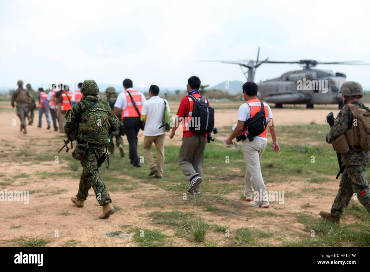 Evakuierten werden zu einem US-Marinekorps CH-46E Sea Knight Helikopter geführt, während der Durchführung einer multinationalen Notevakuierung Bohrmaschine 17 Februar in Pattaya, Chonburi Provinz, Königreich von Thailand, während des Trainings Cobra Gold 2013. Militärangehörige aus Thailand, Japan, Indonesien und Malaysia arbeitete zusammen mit US-Marines und Matrosen von der 31. Marine Expeditionary Unit multinationale Bürger durch Sicherheit und screening-Stationen vor evakuieren sie per Hubschrauber zu verarbeiten. Kobra-Gold ist die größte multinationale Übung in der Asien-Pazifik-Region und trägt zur Entwicklung Interoperabilität zwischen par Stockfoto