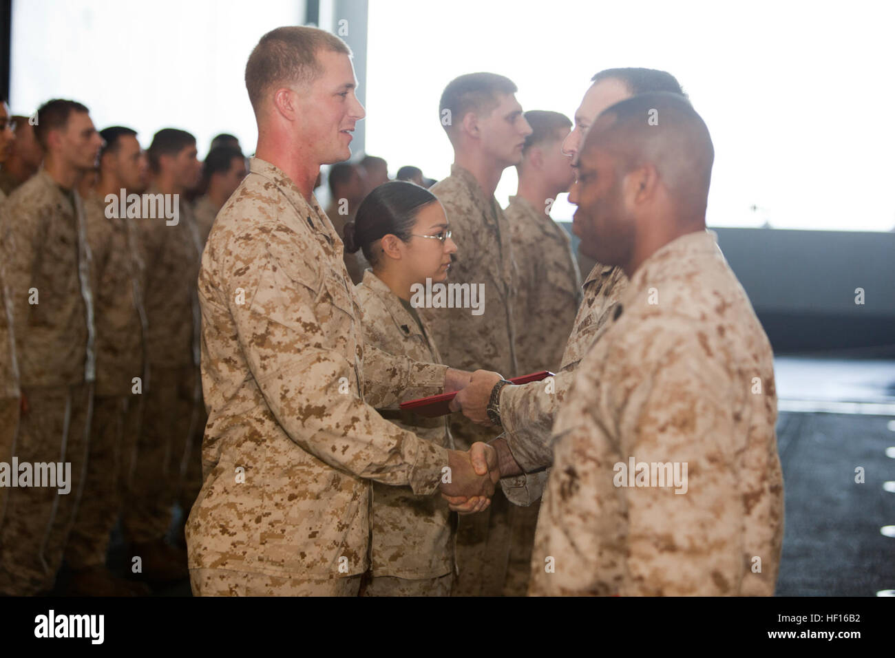 Aufsteiger SGT Stephen Spencer, Draht-Chef, Joint Task Force-Enabler, 15. Marine Expeditionary Unit, schüttelt Hände mit Oberst Scott D. Campbell, sein kommandierender Offizier im Hangar Bucht der USS Peleliu, März 1. Die 15. MEU bereitgestellt wird als Teil der Peleliu amphibische bereit Gruppe als US Central Command Theater Reserve Kraft, Unterstützung für maritime Sicherheit und Theater Kooperationen in den USA 5. Flotte Aufgabengebiet. (Foto: U.S. Marine Corps CPL. Danny L. Shaffer) Westlichen Pazifischen Bereitstellung 12-2 130301-M-BM539-012 Stockfoto